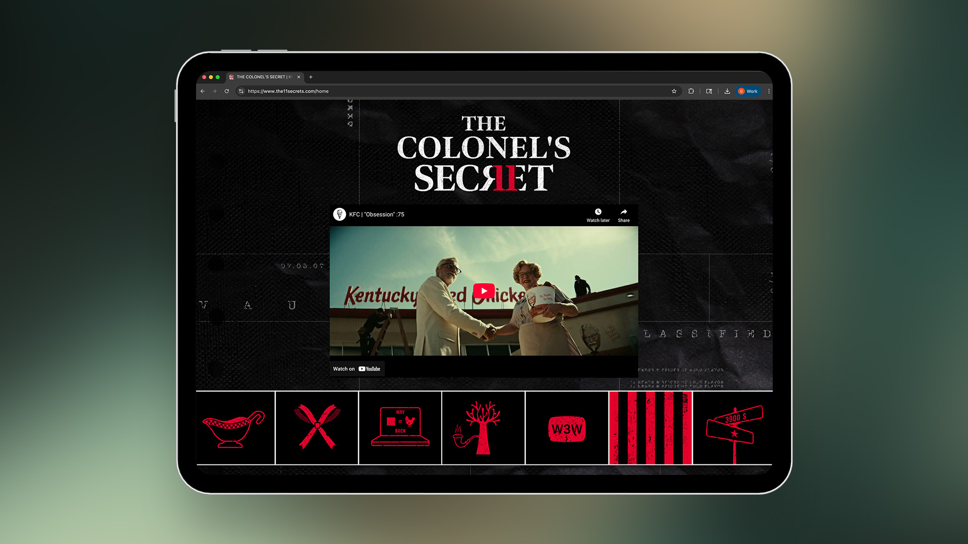 A tablet shows KFC's 11 Secrets website, The Colonel's Secret, with a film above a row of red icons