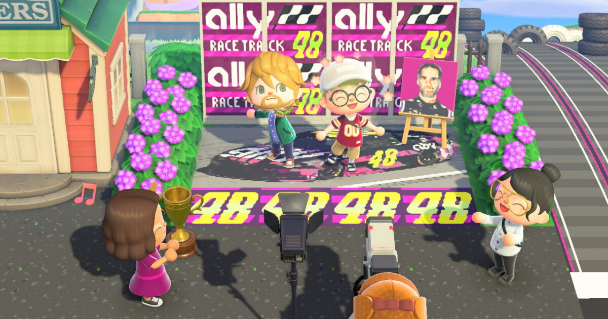 Animal Crossing characters pose in front of Ally Race Track 48 banners, with a trophy, studio cameras and a portrait on an easel, on Ally Island
