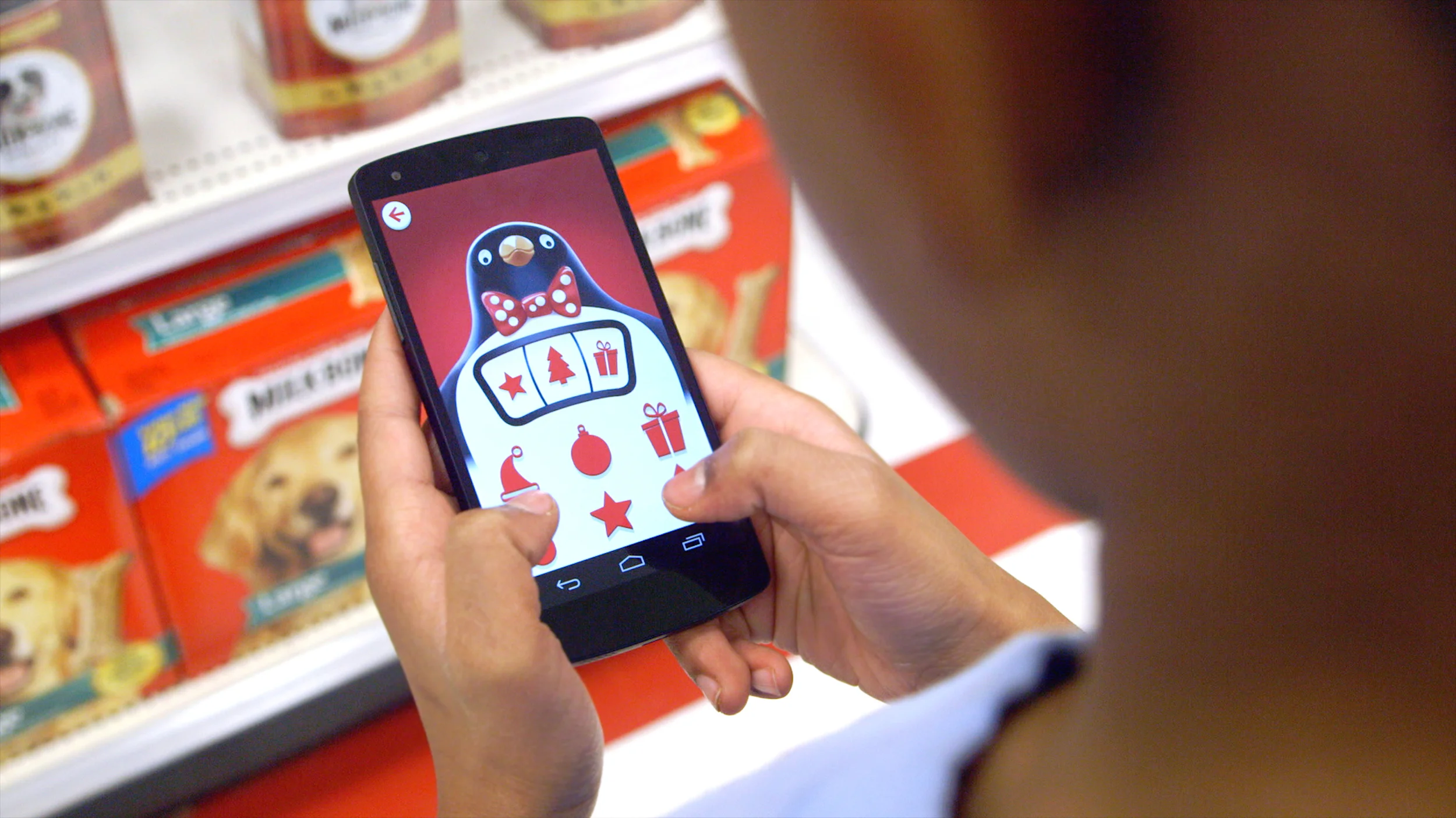 A person in a store aisle taps festive symbols on a penguin's chest in Target's Bullseye's Playground