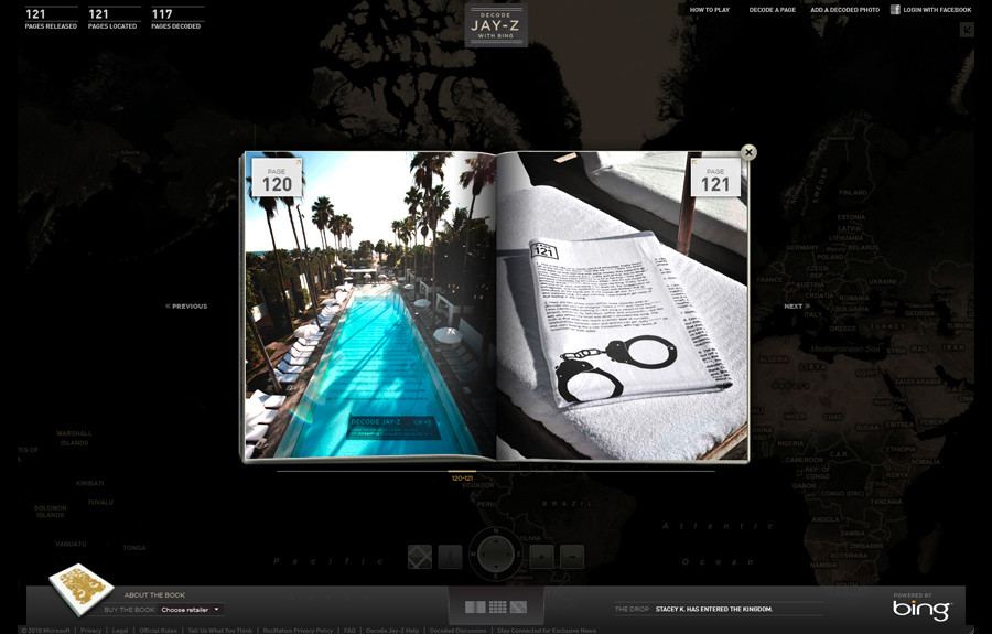 Decode Jay-Z with Bing: the site's book view open at pages 120 and 121, one a printed panel on the floor of a palm-lined swimming pool, the other a page with a drawing of handcuffs on a folded white towel, over a dark world map with counters for pages released, located and decoded
