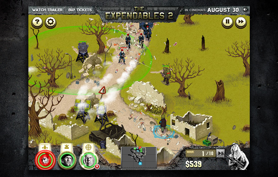 Deploy & Destroy for The Expendables 2: soldiers in red berets advance along a dirt track past ruined walls and dead trees towards gun towers, under Watch Trailer and Buy Tickets buttons and an In cinemas August 30 banner, with three squad portraits, a minimap, a wave counter at 1 of 10 and $539 along the bottom