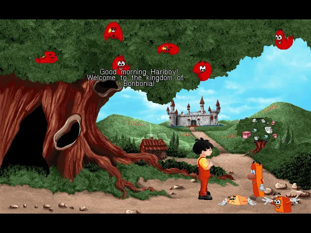 Haribo's Hariboy's Quest: Hariboy stands under a big tree with red characters in its branches as on-screen text welcomes him to the kingdom of Bonbonia, with a castle on the hill behind
