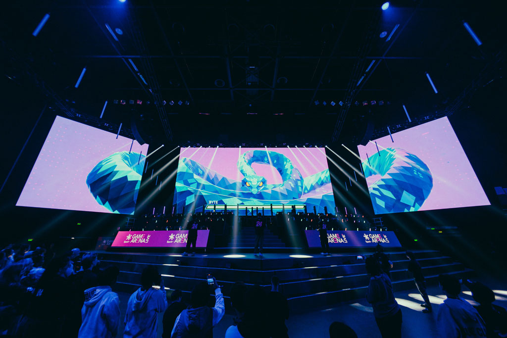 Killabyte's snake Byte across three stage screens above a crowd and Spark Game Arena banners