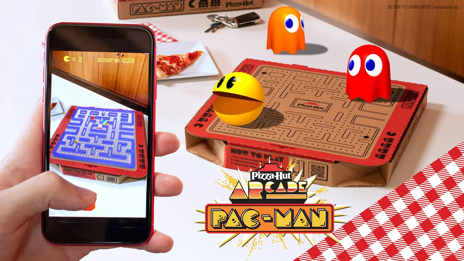 WebAR PAC-MAN Box for Pizza Hut: a hand holds a phone showing the box lid's maze glowing blue with ghosts, a score of 820 and two lives left, next to a Pizza Hut box with a 3D Pac-Man and two ghosts around its printed maze and the Pizza Hut Arcade logo