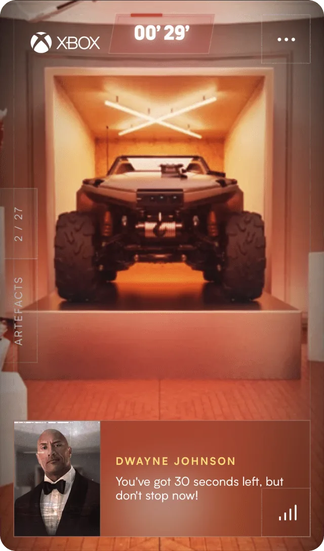 Phone screen from The Xbox Vault by Xbox: an off-road vehicle in a lit alcove, a timer at 00'29, an artefacts counter at 2 of 27 and a message from Dwayne Johnson saying 30 seconds are left